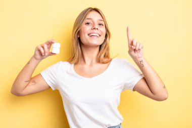 Güzel sarışın kız bir fikri fark ettikten sonra mutlu ve heyecanlı bir dahi gibi hissediyor. hap şişesi konsepti