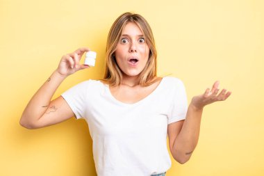 Güzel sarışın kız şok olmuş ve şaşırmış hissediyor. hap şişesi konsepti