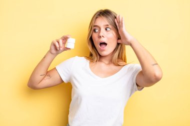 Güzel sarışın kız mutlu, heyecanlı ve şaşırmış hissediyor. hap şişesi konsepti