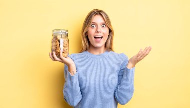 Güzel sarışın kız kendini mutlu hissediyor ve inanılmaz bir şeye hayret ediyor. Ev yapımı kurabiye konsepti