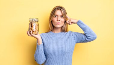 Güzel sarışın kız şaşkın ve şaşkın hissediyor, senin deli olduğunu gösteriyor. Ev yapımı kurabiye konsepti