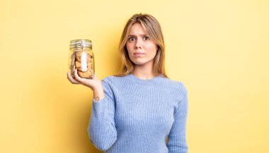 Güzel sarışın kız üzgün, üzgün ya da kızgın ve yana bakıyor. Ev yapımı kurabiye konsepti