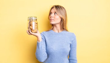 Profil görünümündeki güzel sarışın kız hayal mi kuruyor, hayal mi kuruyor yoksa hayal mi kuruyor? Ev yapımı kurabiye konsepti