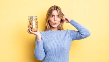 Güzel sarışın kız şaşırmış görünüyor, yeni bir düşünce, fikir ya da konsept fark ediyor. Ev yapımı kurabiye konsepti