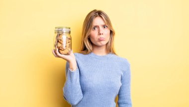 Güzel sarışın kız üzgün ve mızmızlanıyor. Mutsuz bir bakışı var ve ağlıyor. Ev yapımı kurabiye konsepti