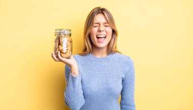 Güzel sarışın kız agresif bir şekilde bağırıyor, çok kızgın görünüyor. Ev yapımı kurabiye konsepti