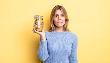 Güzel sarışın kız şaşkın ve şaşkın görünüyor. Ev yapımı kurabiye konsepti