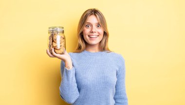 Güzel sarışın kız mutlu ve hoş bir şekilde şaşırmış görünüyor. Ev yapımı kurabiye konsepti