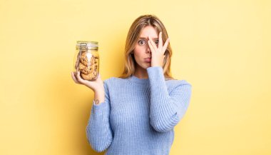 Güzel sarışın kız bıkkın, yorgun ve uykulu hissediyor. Ev yapımı kurabiye konsepti