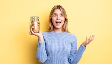 Güzel sarışın kız kendini mutlu hissediyor, bir çözüm ya da fikir bulduğuna şaşırıyor. Ev yapımı kurabiye konsepti