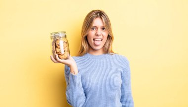 Güzel sarışın kız iğreniyor, sinirleniyor ve dilini çıkarıyor. Ev yapımı kurabiye konsepti