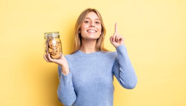 Güzel sarışın kız bir fikri fark ettikten sonra mutlu ve heyecanlı bir dahi gibi hissediyor. Ev yapımı kurabiye konsepti