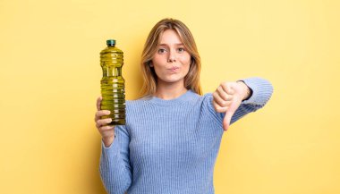 Güzel sarışın kız kendini kötü hissediyor, baş parmağını kaldırıyor. Zeytin yağı kavramı