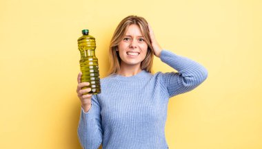 Güzel sarışın kız stresli, endişeli ya da korkmuş, elleri başının üstünde. Zeytin yağı kavramı