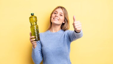 Güzel sarışın kız gururlu, olumlu gülümsüyor. Zeytin yağı kavramı