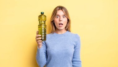 Güzel sarışın kız çok şaşırmış ya da şaşkın görünüyor. Zeytin yağı kavramı