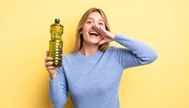 Güzel sarışın kız kendini mutlu hissediyor, elleri ağzının kenarında bağırıyor. Zeytin yağı kavramı