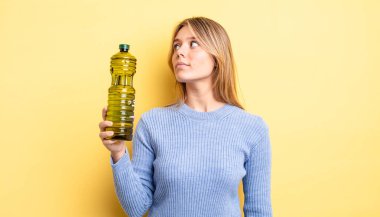 Profil görünümündeki güzel sarışın kız hayal mi kuruyor, hayal mi kuruyor yoksa hayal mi kuruyor? Zeytin yağı kavramı