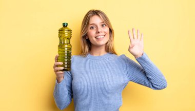 Güzel sarışın kız gülümsüyor ve arkadaş canlısı görünüyor, dört numarayı gösteriyor. Zeytin yağı kavramı