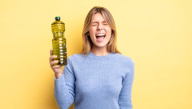 Güzel sarışın kız agresif bir şekilde bağırıyor, çok kızgın görünüyor. Zeytin yağı kavramı