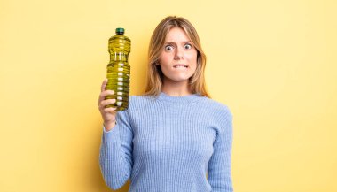 Güzel sarışın kız şaşkın ve şaşkın görünüyor. Zeytin yağı kavramı