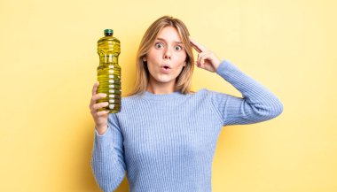 Güzel sarışın kız şaşırmış görünüyor, yeni bir düşünce, fikir ya da konsept fark ediyor. Zeytin yağı kavramı