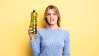 Güzel sarışın kız şaşkın ve şaşkın hissediyor. Zeytin yağı kavramı