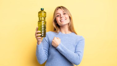 Güzel sarışın kız kendini mutlu hissediyor ve bir meydan okumayla yüzleşiyor ya da kutluyor. Zeytin yağı kavramı