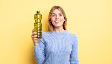 Güzel sarışın kız mutlu ve hoş bir şekilde şaşırmış görünüyor. Zeytin yağı kavramı