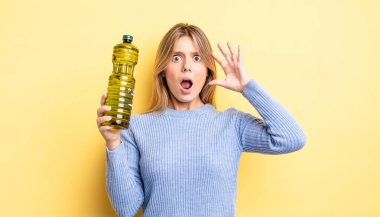 Güzel sarışın kız ellerini havaya kaldırarak çığlık atıyor. Zeytin yağı kavramı