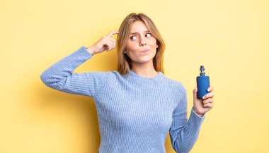 Güzel sarışın kız şaşkın ve kafası karışık, kaşınan bir kafa hissediyor. duman buharlaştırıcı kavramı