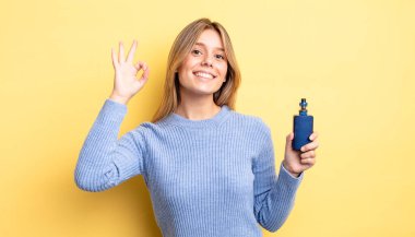 Güzel sarışın kız kendini mutlu hissediyor, iyi bir jestle onaylıyor. duman buharlaştırıcı kavramı