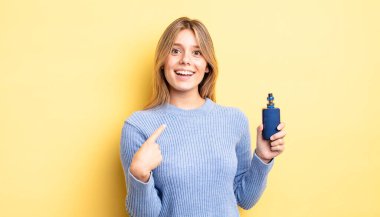 Güzel sarışın kız mutlu hissediyor ve heyecanla kendini işaret ediyor. duman buharlaştırıcı kavramı