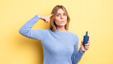 Güzel sarışın kız şaşkın ve şaşkın hissediyor, senin deli olduğunu gösteriyor. duman buharlaştırıcı kavramı