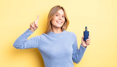 Güzel sarışın kız gülümsüyor ve arkadaş canlısı görünüyor. Bir numarayı gösteriyor. duman buharlaştırıcı kavramı