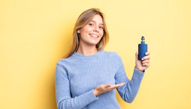 Güzel sarışın kız neşeyle gülümsüyor, mutlu hissediyor ve bir konsept gösteriyor. duman buharlaştırıcı kavramı