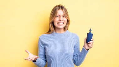 Güzel sarışın kız sinirli, sinirli ve sinirli görünüyor. duman buharlaştırıcı kavramı