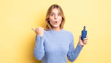 Güzel sarışın kız inançsızlıktan şaşkın şaşkın bakıyor. duman buharlaştırıcı kavramı