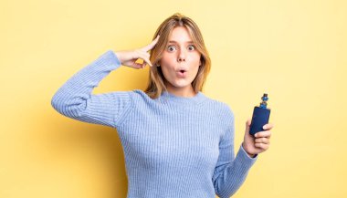 Güzel sarışın kız şaşırmış görünüyor, yeni bir düşünce, fikir ya da konsept fark ediyor. duman buharlaştırıcı kavramı