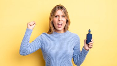 Güzel sarışın kız sinirli bir ifadeyle agresif bir şekilde bağırıyor. duman buharlaştırıcı kavramı