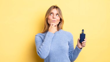 Güzel sarışın kız düşünüyor, kuşkulu ve şaşkın hissediyor. duman buharlaştırıcı kavramı