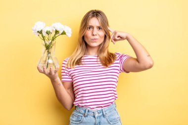 Güzel sarışın kız şaşkın ve şaşkın hissediyor, senin deli olduğunu gösteriyor. Dekoratif çiçek konsepti