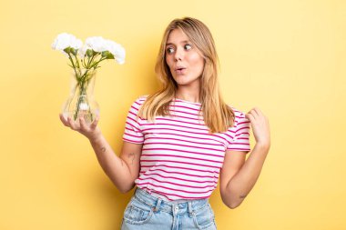 Güzel sarışın kız stresli, endişeli, yorgun ve hayal kırıklığına uğramış hissediyor. Dekoratif çiçek konsepti