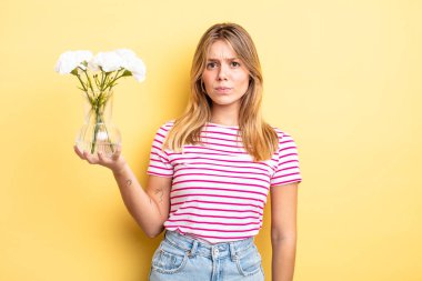 Güzel sarışın kız üzgün, üzgün ya da kızgın ve yana bakıyor. Dekoratif çiçek konsepti