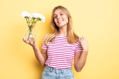 Güzel sarışın kız kibirli, başarılı, pozitif ve gururlu görünüyor. Dekoratif çiçek konsepti