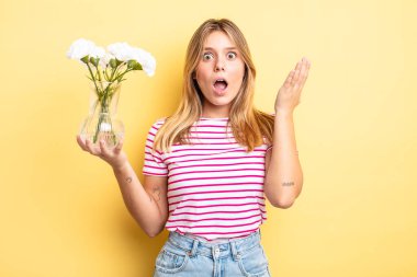 Güzel sarışın kız inanılmaz bir sürprizle şaşkına döndü ve hayrete düştü. Dekoratif çiçek konsepti