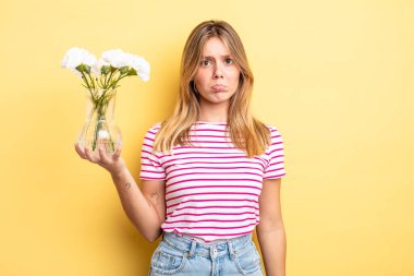 Güzel sarışın kız üzgün ve mızmızlanıyor. Mutsuz bir bakışı var ve ağlıyor. Dekoratif çiçek konsepti