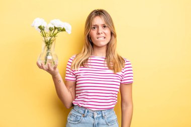 Güzel sarışın kız şaşkın ve şaşkın görünüyor. Dekoratif çiçek konsepti