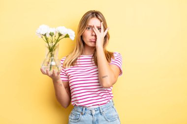 Güzel sarışın kız bıkkın, yorgun ve uykulu hissediyor. Dekoratif çiçek konsepti