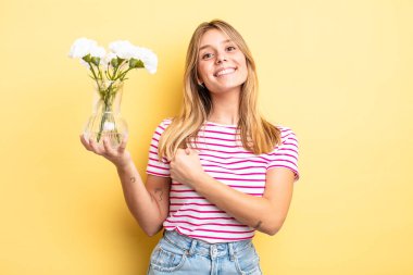 Güzel sarışın kız kendini mutlu hissediyor ve bir meydan okumayla yüzleşiyor ya da kutluyor. Dekoratif çiçek konsepti